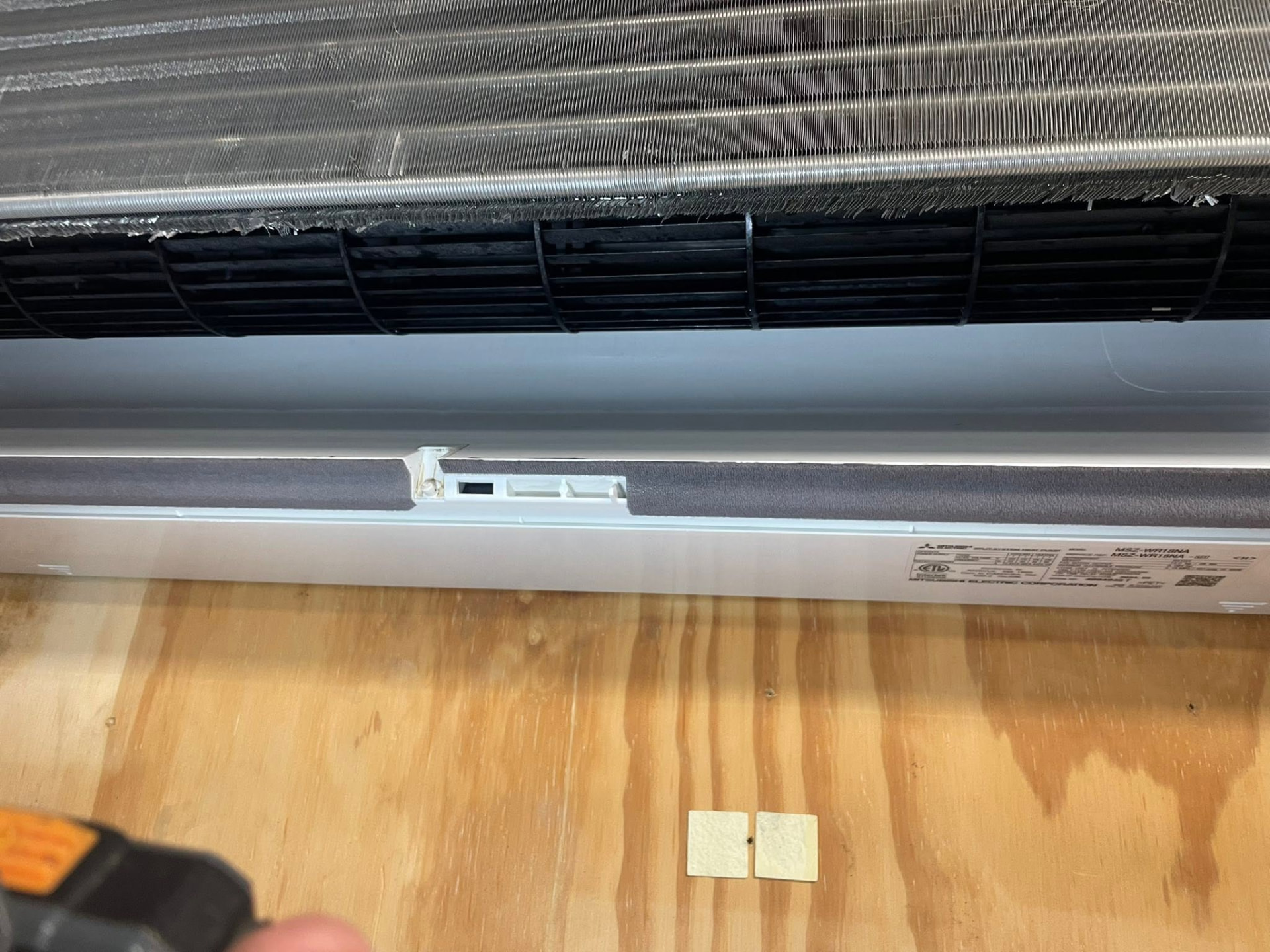 Mitsubishi ductless mini-split being serviced by a technician